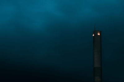 Illuminated lighthouse against sky at night