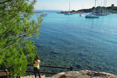 Rear view of woman standing and enjoying beautiful mediterranean landscape during the holidays 