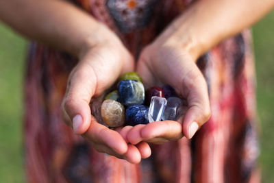 Midsection of woman holding stones