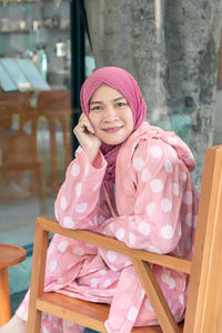 Portrait of smiling woman sitting on chair