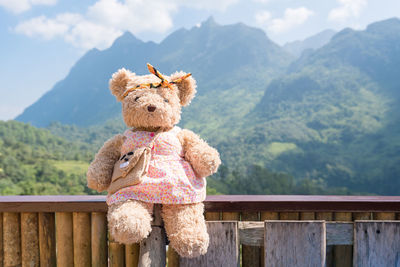 Full length of boy toy on railing against mountain range