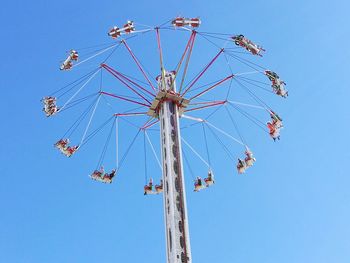 Low angle view of ferris wheel against clear blue sky