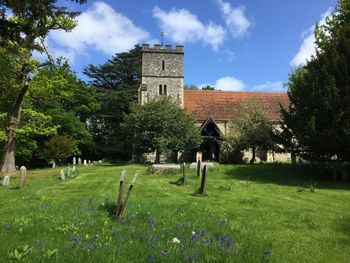 Cemetery by old church against sky