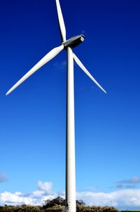 Low angle view of windmill against blue sky