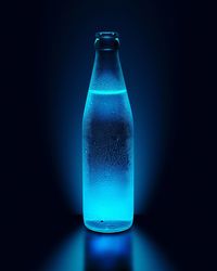 Close-up of drink in glass bottle against black background