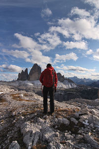 Rear view of woman standing on mountain against sky - tre cime di lavaredo - dolomiti - italy