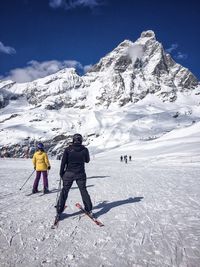 People walking on snow covered landscape