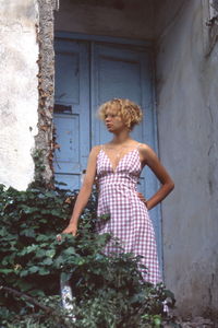 Full length of woman standing against built structure