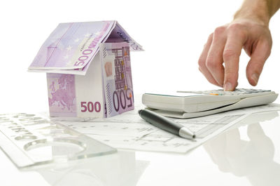 Midsection of person holding paper against white background