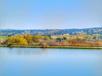 Scenic view of lake against clear blue sky