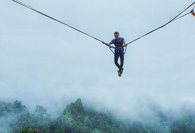 A man swing in the sky by rope