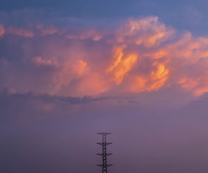 Low angle view of communications tower against sky during sunset