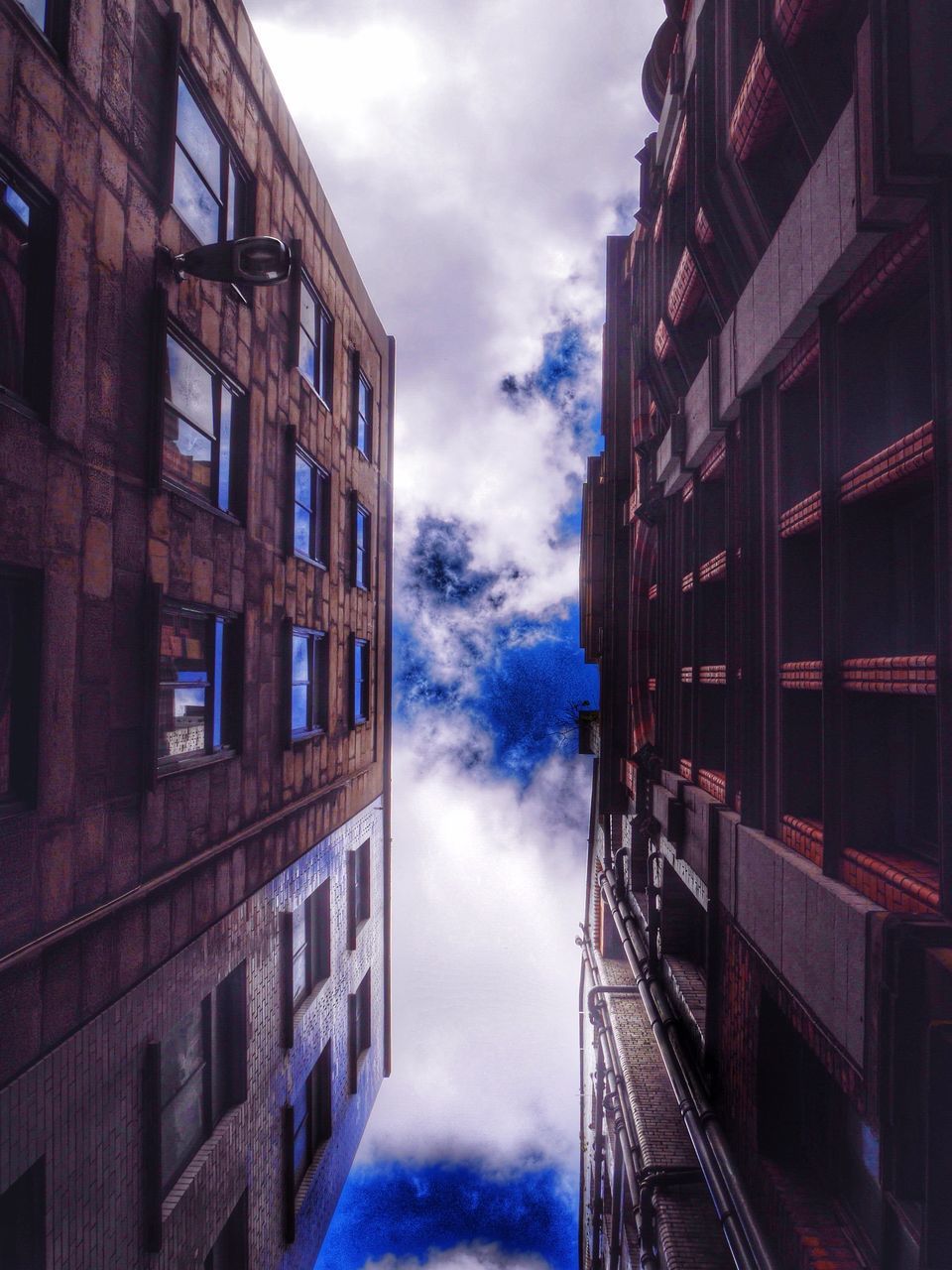 architecture, building exterior, built structure, sky, cloud - sky, cloudy, building, city, weather, overcast, window, residential building, residential structure, cloud, low angle view, reflection, transportation, outdoors, dusk, street