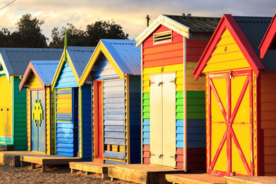 Close up of colourful bathing boxes in brighton beach against sky