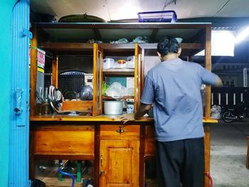 Rear view of man working in kitchen