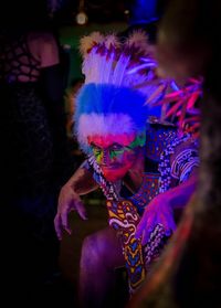 Midsection of man holding multi colored feathers