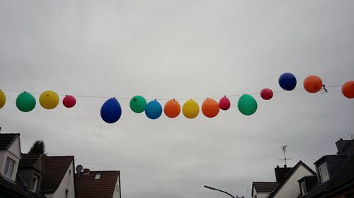 Low angle view of balloons flying against sky