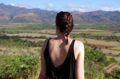 Rear view of woman standing looking at mountains