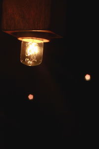 Lit lamp hanging at night