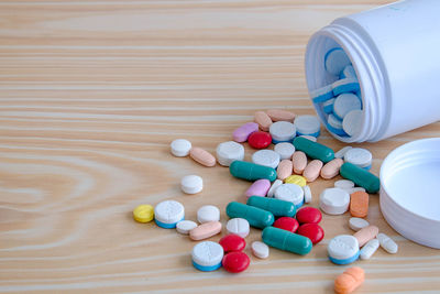 High angle view of pills with container on table