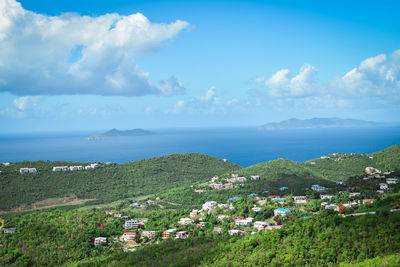 Scenic view of sea by buildings against sky