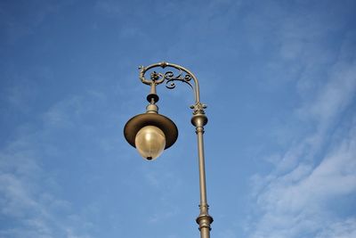 Low angle view of communications tower against cloudy sky