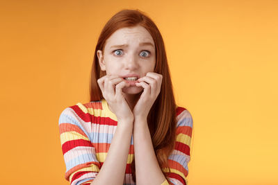 Portrait of woman against yellow background