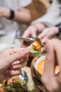 Cropped image of people holding food