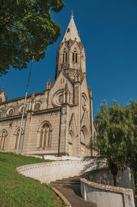 Church of santa terezinha and belfry on top of hill, in a sunny day at sao manuel, brazil.