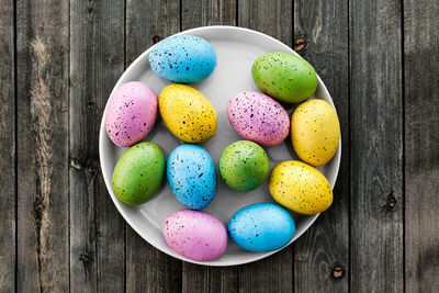 Directly above view of multi colored eggs on wooden table