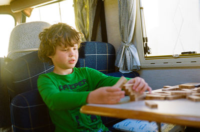 Boy sitting on table with blocks at motor home