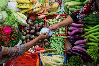 Cropped image of customer paying to vendor in market