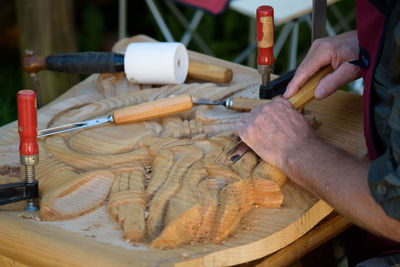 Midsection of man carving wood