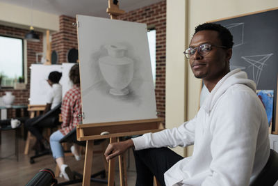 Portrait of young man sitting in classroom