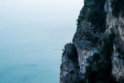 Close-up of rock by sea against sky