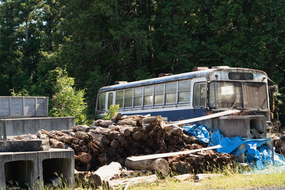 Abandoned truck on field against trees