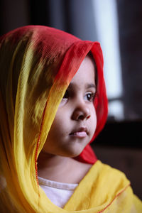 Close-up of cute girl wearing scarf at home