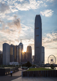Buildings in city against cloudy sky