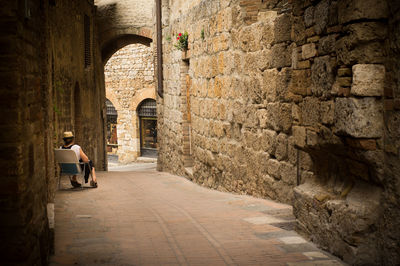 People walking on footpath by historic building