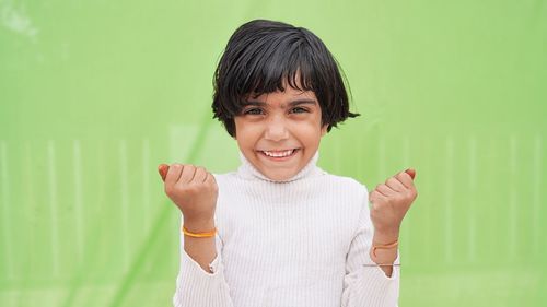 Cute asian girl, 6 to 7 years old, black hair, white sleeveless shirt. she clenched her fists and ra