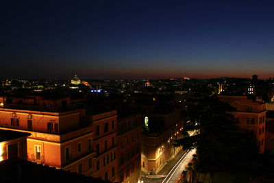 High angle view of illuminated buildings against sky at night