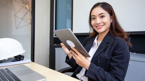 Portrait of young businesswoman using digital tablet in office