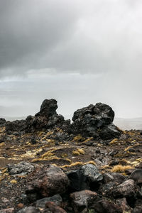 Rocks on sea shore against sky