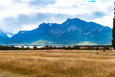 Scenic view of field and mountains against sky