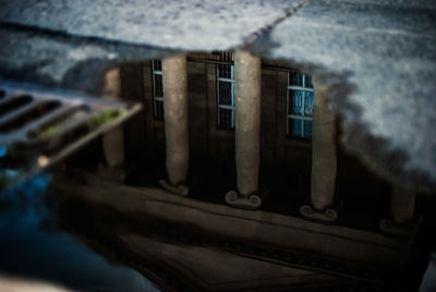 Reflection of historic building in puddle