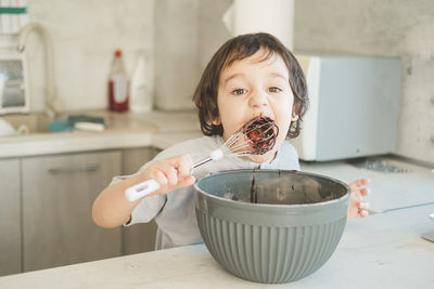 A little boy is cooking in the kitchen.