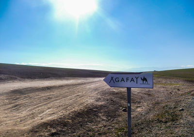 Information sign on road against sky