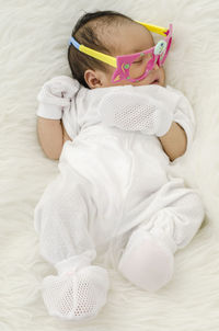High angle view of newborn girl sleeping on bed at home