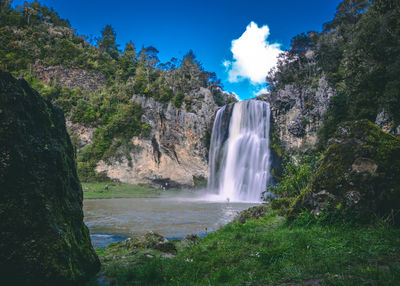 Scenic view of waterfall against sky