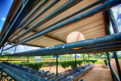 Low angle view of baseball ball on railing